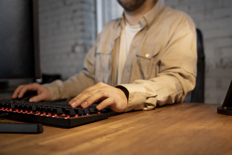 Homme utilisant un clavier mécanique silencieux